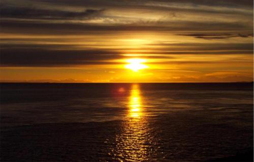 a sunset over the ocean with the sun in the sky at 4 Bedroom Stunning Home In Jesendorf in Jesendorf