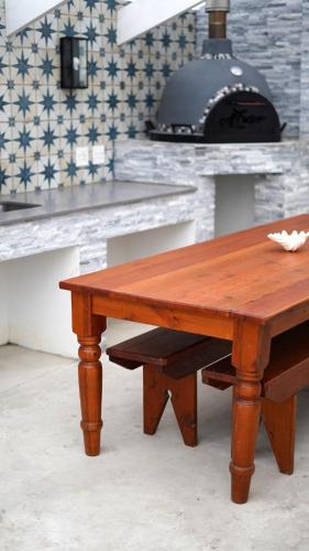a wooden table in a kitchen with a stove at The Cottage in Morganʼs Bay