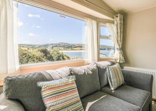 a living room with a couch and a large window at Waters Edge Leisure Park in Cardigan