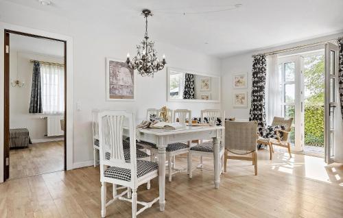 福堡Pet Friendly Home In Faaborg With Wifi的一间有白色桌子和椅子的餐厅
