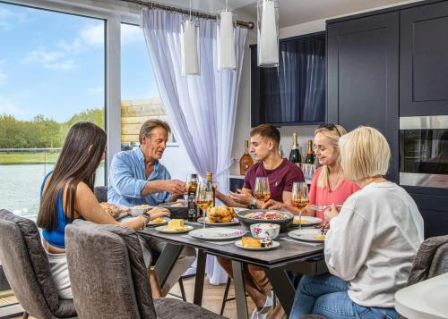 un grupo de personas sentadas alrededor de una mesa comiendo comida en Noahs Retreat en Laceby