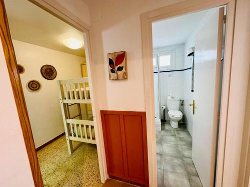 ein Bad mit einem WC und einer roten Tür in der Unterkunft Les cases del vent I in L'Ametlla de Mar