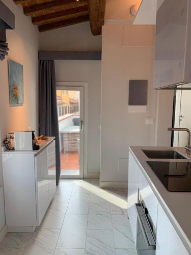 a kitchen with white cabinets and a tile floor at Kairos by Florence Art Apartments in Florence