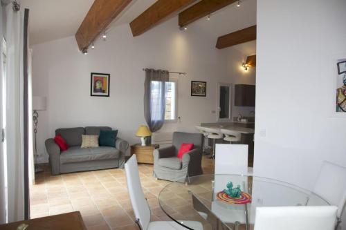 Una sala de estar con una mesa de cristal y sillas. en T3 coeur de Sanary - 100m du port, en Sanary-sur-Mer