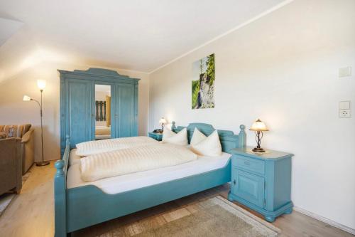 a bedroom with a blue bed and a blue cabinet at Pension Bergblick in Marienberg