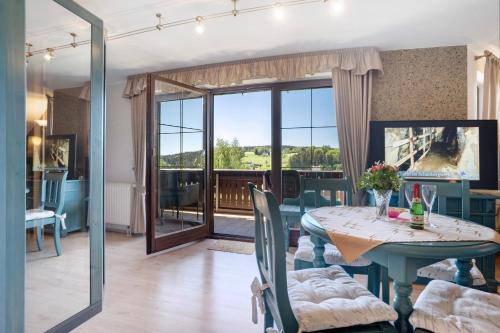 a dining room with a table and a balcony at Pension Bergblick in Marienberg