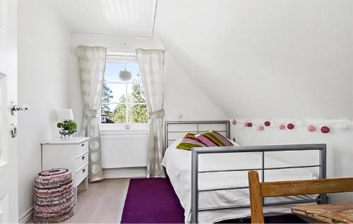 a small bedroom with a bed and a window at Cozy Home In Nykping With House Sea View in Oxelösund