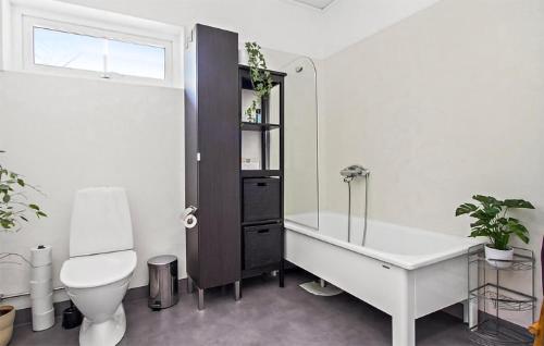 a bathroom with a tub and a toilet and a sink at Cozy Home In Nykping With House Sea View in Oxelösund