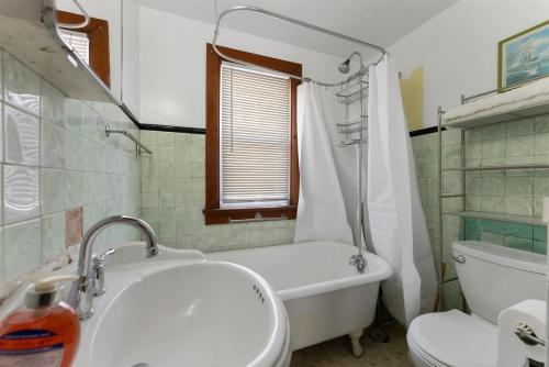 113 E 24th Ave, 2nd Floor في شمال وايلدوود: حمام مع حوض وحوض استحمام ومرحاض