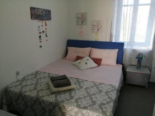 une chambre avec un grand lit et une tête de lit bleue dans l'établissement Welcome to Giouli's home !, à Elafonisos