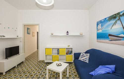 ein Wohnzimmer mit einem blauen Sofa und einem Fernseher in der Unterkunft Nice Home In Marina Di Ragusa in Marina di Ragusa
