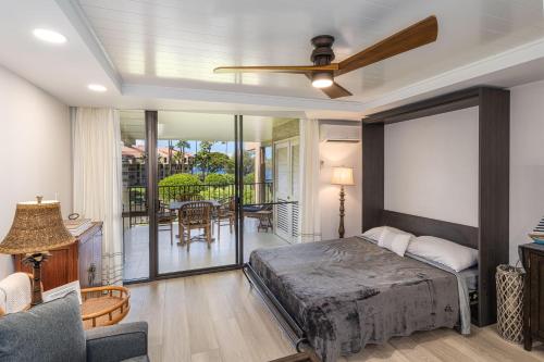 a bedroom with a bed and a balcony at Kamaole Sands 1-305 in Wailea