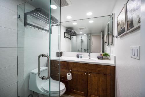 a bathroom with a toilet and a glass shower at Kamaole Sands 1-305 in Wailea