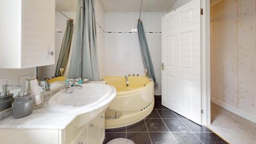 a bathroom with a yellow toilet and a sink at Charming 5 bedroom house in Grays in Grays Thurrock