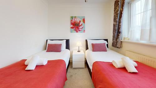 two beds sitting next to each other in a bedroom at Charming 5 bedroom house in Grays in Grays Thurrock