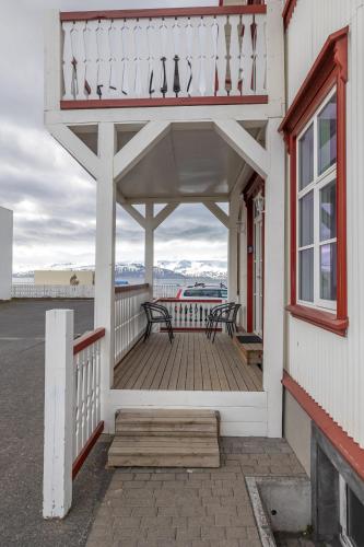 a porch with two benches on a building at Bjarnabúð in Húsavík