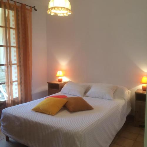 une chambre avec un lit blanc avec deux oreillers dessus dans l'établissement Coeur de ville avec jardin privatif, à Sanary-sur-Mer