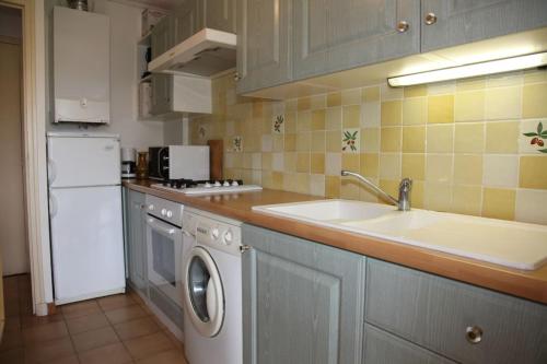 une cuisine avec un évier et une machine à laver dans l'établissement Coeur de ville avec jardin privatif, à Sanary-sur-Mer