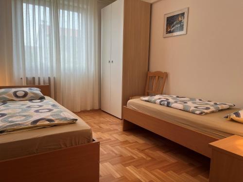 a bedroom with two beds and a table and a window at Apartment LAGUNA 37 in Izola