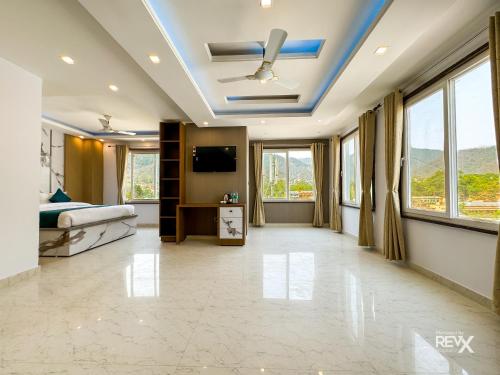 1 dormitorio con 1 cama y TV en el techo en Hotel Vaidik Ganga , Near Parmarth Niketan en Rishīkesh