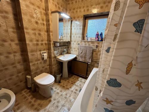 a bathroom with a toilet and a sink and a tub at Apartment LAGUNA 37 in Izola