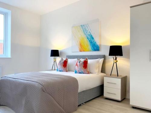 a bedroom with a white bed with two lamps at Altitude at Fleet Heights Apartment One in Fleet