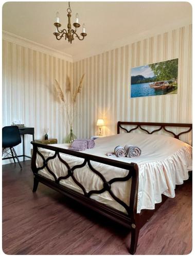 um quarto com uma cama grande e um lustre em Chambre au calme em Lagarrigue
