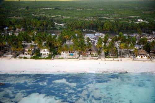 an aerial view of a white beach with houses at Zanzistar Lodge in Jambiani