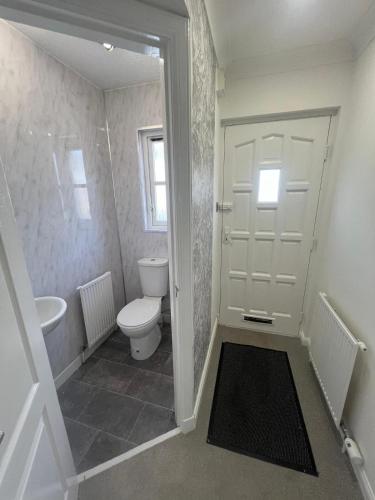 a white bathroom with a toilet and a sink at No 6, Ayr, 140m2, New Decor 2024, 3bedroom, detached house, with private gardens in Ayr