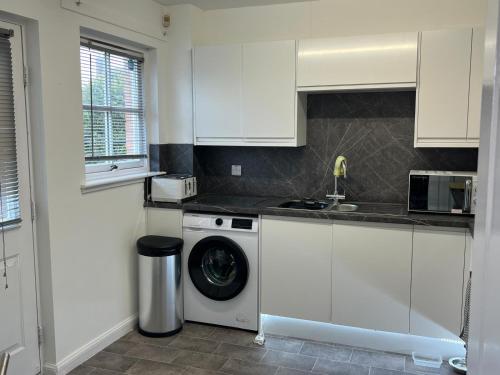 a white kitchen with a washing machine in it at No 6, Ayr, 140m2, New Decor 2024, 3bedroom, detached house, with private gardens in Ayr