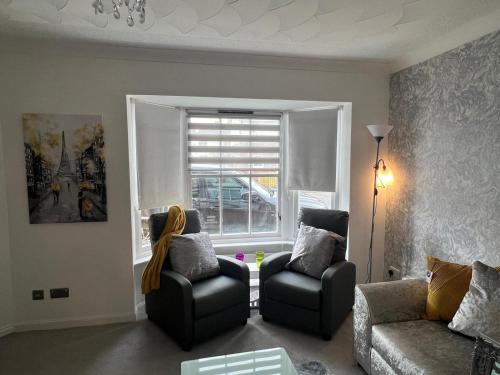 a living room with two chairs and a window at No 6, Ayr, 140m2, New Decor 2024, 3bedroom, detached house, with private gardens in Ayr