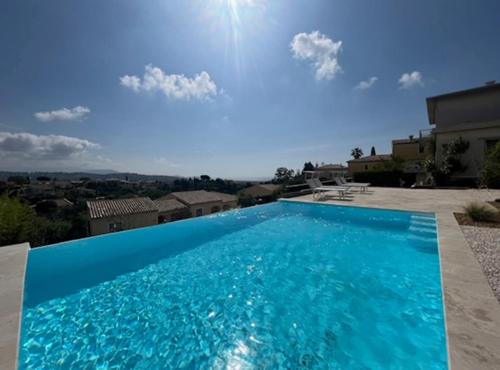 - une grande piscine bleue au-dessus d'une maison dans l'établissement DOMAINE LOU BEL AZUR - Panoramique, à Saint-Laurent-du-Var