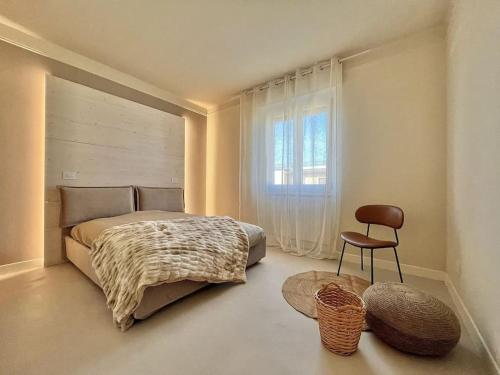 a bedroom with a bed and a chair and a window at Petite Suite Vittoria - Brescia City - by Host4U in Brescia