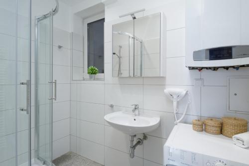 y baño blanco con lavabo y ducha. en Apartment Kröllgasse I contactless check-in, en Viena