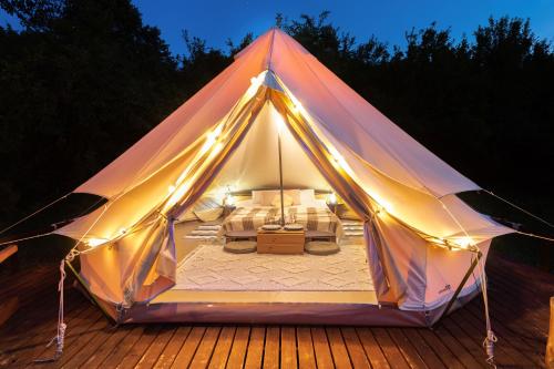 a tent with a bed in it at night at Banki Green Istrian Village - Holiday Homes & Glamping Tents in Bašići