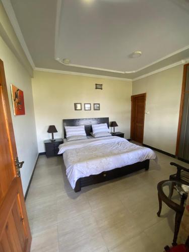 1 dormitorio con 1 cama grande con sábanas blancas en Sikandar Bagh Cottages en Nathia Gali