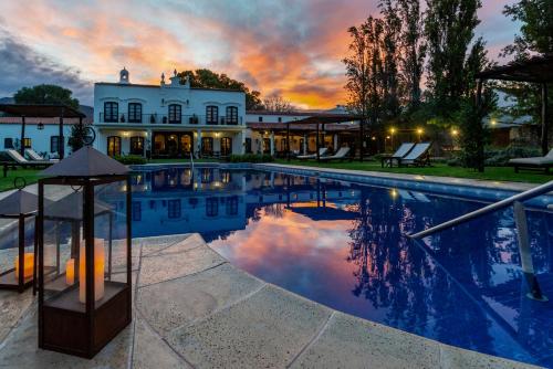 a mansion with a swimming pool at sunset at Patios De Cafayate in Cafayate
