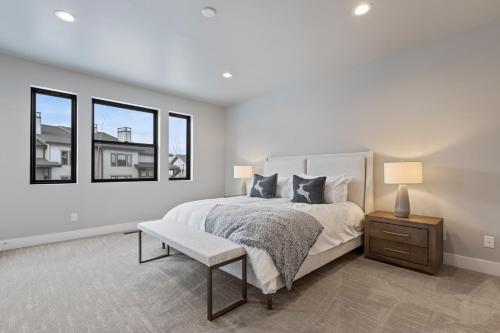 a white bedroom with a bed and two windows at Mayflower Lakeside 1032 by Moose Management in Cranmer