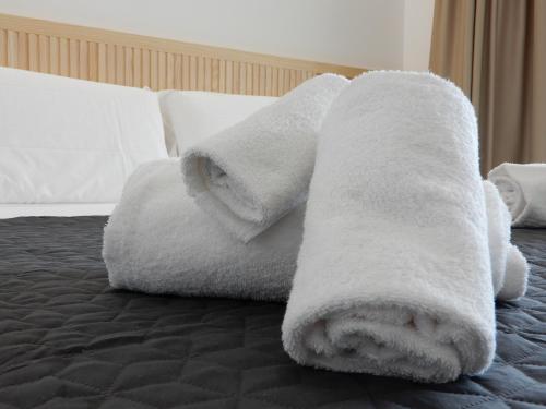 a pile of towels on top of a bed at Middle Town Palace in Tropea