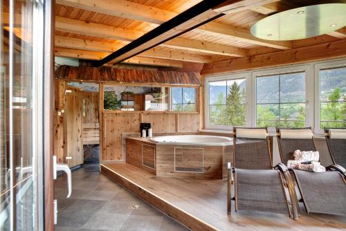 Zimmer mit Badewanne und Stühlen in einer Hütte in der Unterkunft Ferienhaus Plattner in Oetz