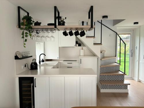 a kitchen with white cabinets and a spiral staircase at GOODMOOSE - Good Mood House in Palanga