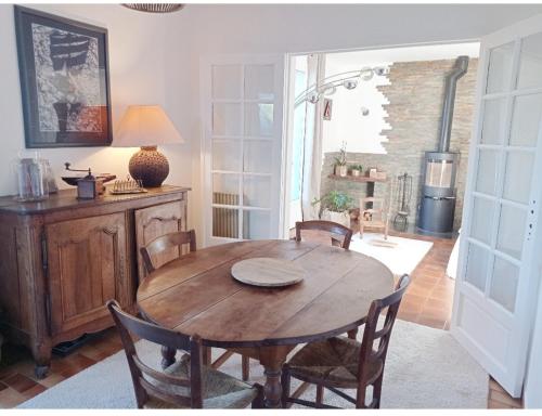 une salle à manger avec une table et des chaises en bois dans l'établissement Maison entière, dans village bord de mer, typique & classé, à Saint-Suliac