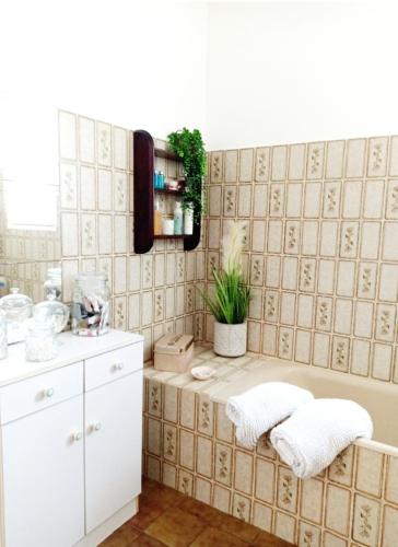 une salle de bain avec une baignoire et deux serviettes dans l'établissement Maison entière, dans village bord de mer, typique & classé, à Saint-Suliac