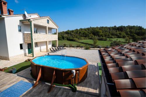 a hot tub in front of a house with seats at Holiday Home Veronica in Labin