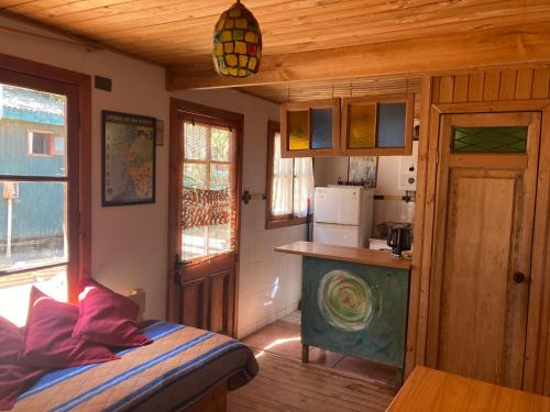 Una pequeña cocina con una cama en una habitación en Cabañas La Magia de Isla Negra, en Isla Negra