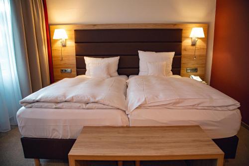 a hotel room with two beds and a table at Hotel Panorama in Einbeck