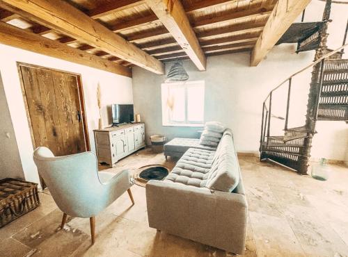 ein Wohnzimmer mit einem Sofa und einem Stuhl in der Unterkunft Le Clos Bohème - Baron in Baron