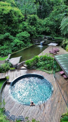 a large swimming pool on a wooden deck at Vila Serra da Luz in Pindamonhangaba