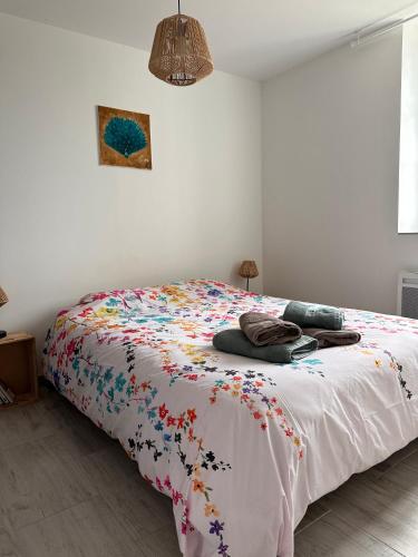 - une chambre blanche avec un lit et une couette colorée dans l'établissement Le Pâtis Karadok - le gîte à la ferme du Karadok'Inn, à Mesvres