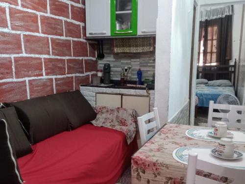 eine Couch neben einem Tisch und einer Ziegelwand in der Unterkunft Casinhas no Interior de MG in Antônio Prado